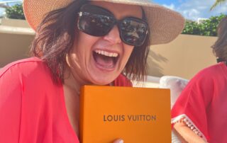 Kristen Lyon, multi-passionate entrepreneur holding orange louis vuitton box