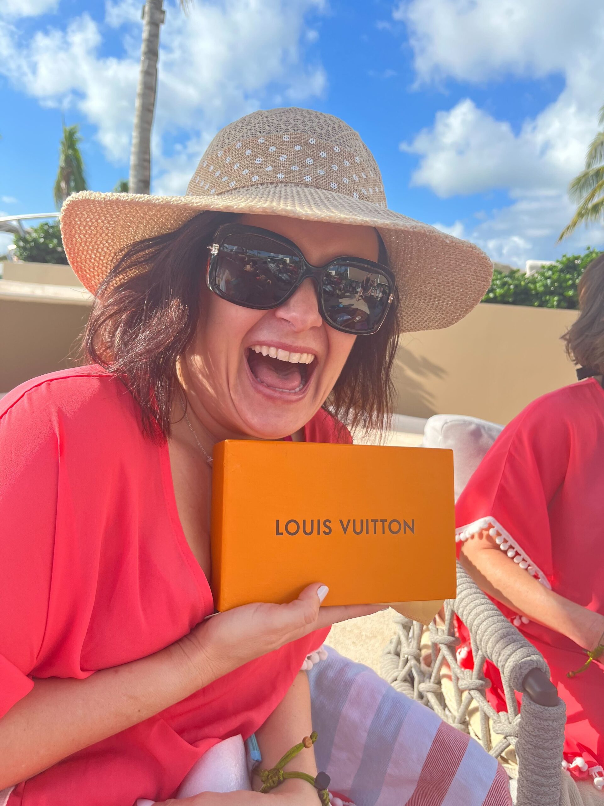 Kristen Lyon, multi-passionate entrepreneur holding orange louis vuitton box