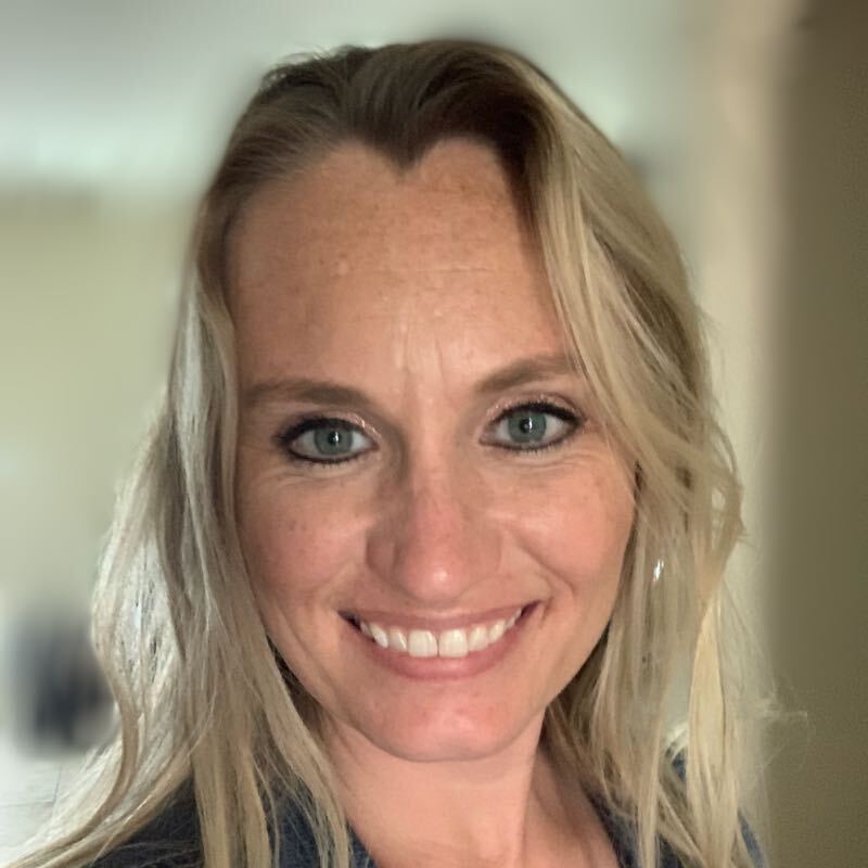 Close up headshot of woman smiling at the camera.